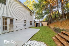 Buford house for rent - a side view of a white house with a concrete driveway and a yard with trees
