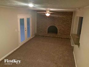 Lithonia house for rent - an empty living room with a brick wall and a white door