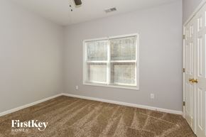 College Park house for rent - a bedroom with a large window and a carpeted floor