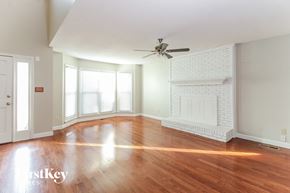 Kernersville house for rent - an empty living room with a fireplace and a ceiling fan