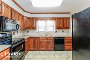 Kernersville house for rent - a kitchen with wooden cabinets and black appliances