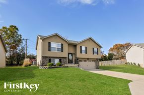 Wentzville house for rent - a beige house with a driveway and a lawn