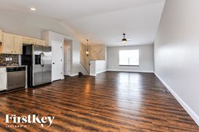 Wentzville house for rent - an empty kitchen and living room with wood flooring and stainless steel appliances