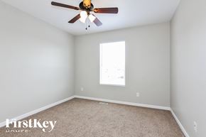 Wentzville house for rent - a bedroom with a ceiling fan and a carpet