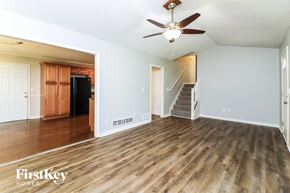 Kennesaw house for rent - A spacious room with wooden floors and a ceiling fan.