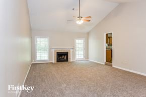 Marietta house for rent - an empty living room with a fireplace and a ceiling fan