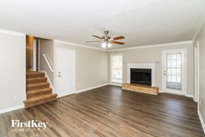 Marietta house for rent - a living room with a fireplace and a ceiling fan