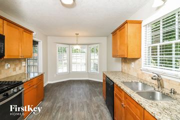Marietta house for rent - a kitchen with wooden cabinets and a sink and a window