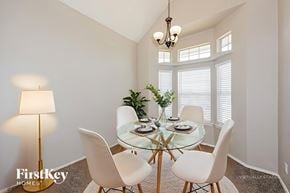 Mesquite house for rent - A dining room with a glass table and white chairs.