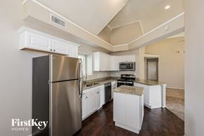 Mesquite house for rent - A kitchen with a stainless steel refrigerator and white cabinets.