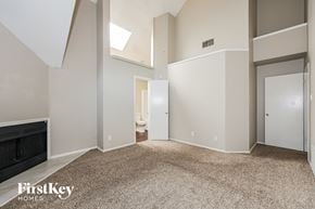 Mesquite house for rent - A spacious room with a skylight and a carpeted floor.