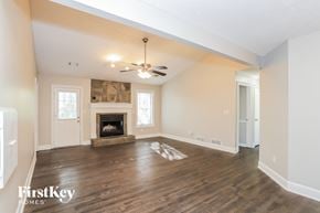 Powder Springs house for rent - A spacious living room with a fireplace and a ceiling fan.