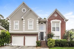 Powder Springs house for rent - a brick house with two garage doors and a lawn
