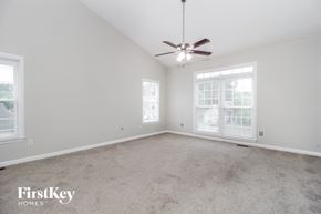 Powder Springs house for rent - an empty living room with a ceiling fan and a window