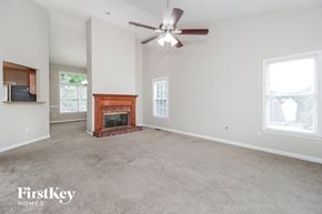Powder Springs house for rent - a living room with a fireplace and a ceiling fan