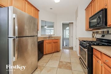 Powder Springs house for rent - a kitchen with stainless steel appliances and wooden cabinets
