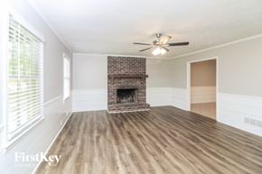 Marietta house for rent - A spacious room with a fireplace and a ceiling fan.