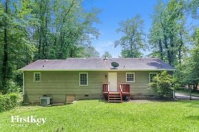 Marietta house for rent - A house with a green lawn and trees in the background.