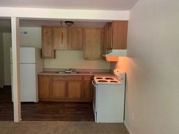 Raleigh apartment for rent - A kitchen with wooden cabinets and a white fridge.