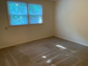Raleigh apartment for rent - A room with a carpeted floor and a window with blinds.