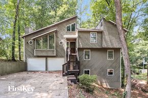 Kennesaw house for rent - front view of a gray house with a driveway and trees