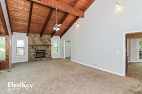 Kennesaw house for rent - a living room with a stone fireplace and a carpeted floor