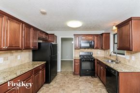 Kennesaw house for rent - a kitchen with wood cabinets and black appliances