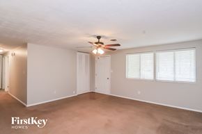 Marietta house for rent - A spacious room with a ceiling fan and two windows with blinds.