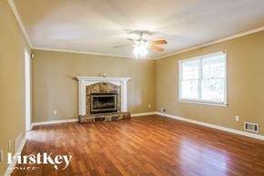Dallas house for rent - a living room with a fireplace and a ceiling fan
