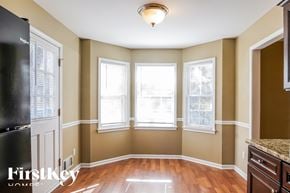 Dallas house for rent - an empty dining room with three windows and a wood floor