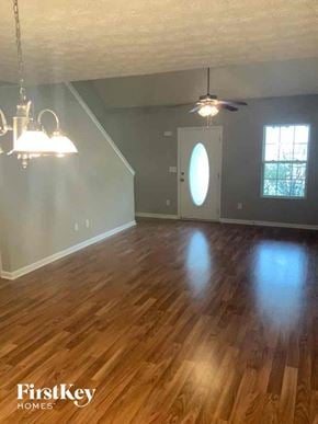 Dallas house for rent - an empty living room with a hard wood floor and a ceiling fan