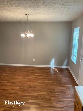 Dallas house for rent - an empty dining room with wooden floors and a chandelier