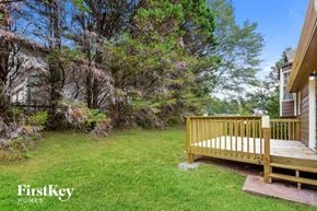 Dallas house for rent - a backyard with a wooden bench in the grass
