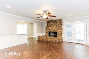 Duncanville house for rent - a living room with a stone fireplace and a ceiling fan
