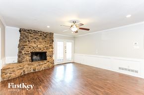 Duncanville house for rent - a living room with a stone fireplace and a ceiling fan