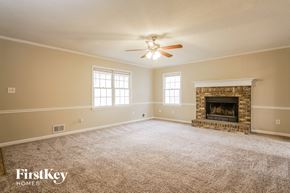 Dallas house for rent - the living room of a home with a ceiling fan and a fireplace