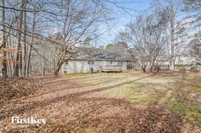 Dallas house for rent - a white house on the side of a yard with trees