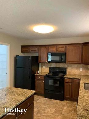 Woodstock house for rent - A kitchen with granite countertops and black appliances.