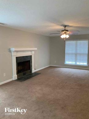 Woodstock house for rent - A living room with a fireplace and a ceiling fan.