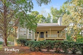 Acworth house for rent - A house with a porch and a tree in front of it.