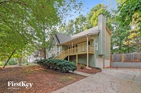Acworth house for rent - A house with a green front yard and a tree with red leaves.