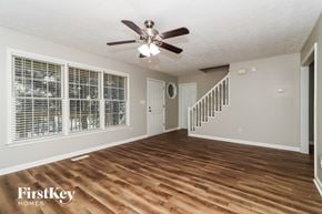 Acworth house for rent - A spacious room with wooden floors and a staircase.