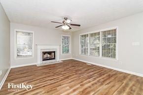 Acworth house for rent - A spacious room with a fireplace and a ceiling fan.
