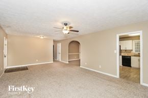 Kennesaw house for rent - an empty living room with a ceiling fan and a kitchen