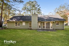 Powder Springs house for rent - A house with a green lawn and trees in the background.