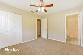 Cocoa house for rent - a bedroom with a ceiling fan and a door to a bathroom
