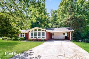 Dallas house for rent - a white and brick house with a driveway and trees