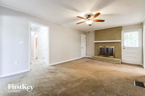 Dallas house for rent - an empty living room with a ceiling fan and a fireplace