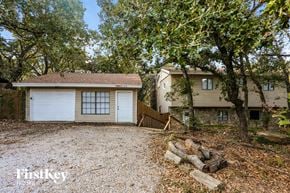 Flower Mound house for rent - A house with a garage is surrounded by trees.