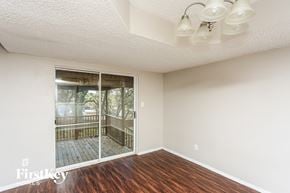 Flower Mound house for rent - A room with a wooden floor and a sliding glass door leading to a balcony.